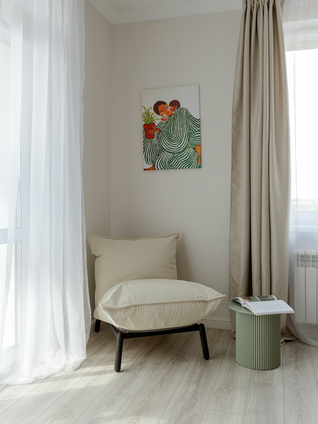 Moderner Lesebereich mit Sessel, Beistelltisch und Kunst.